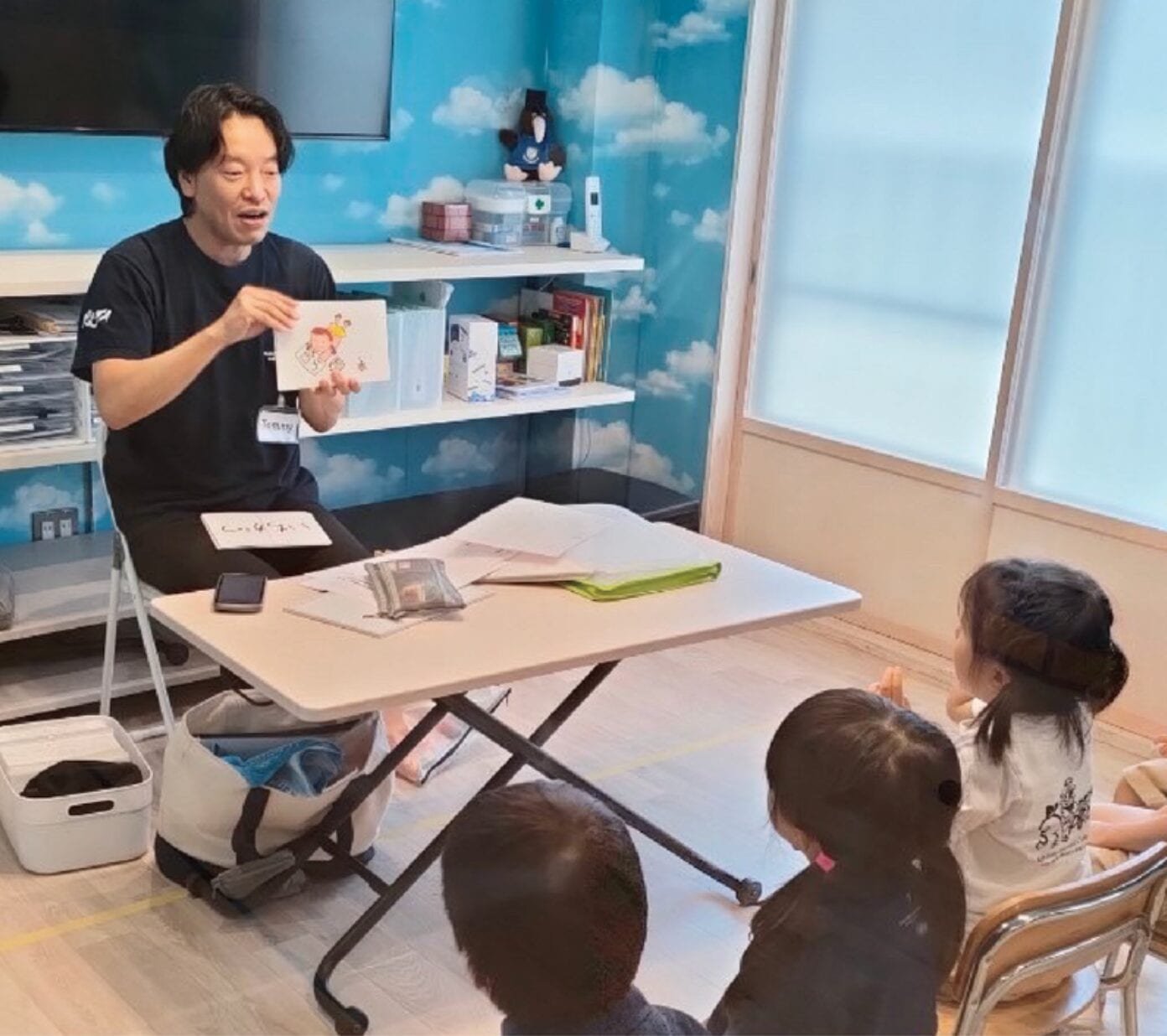 RIT のクラスで子どもたちにカードを見せる先生。